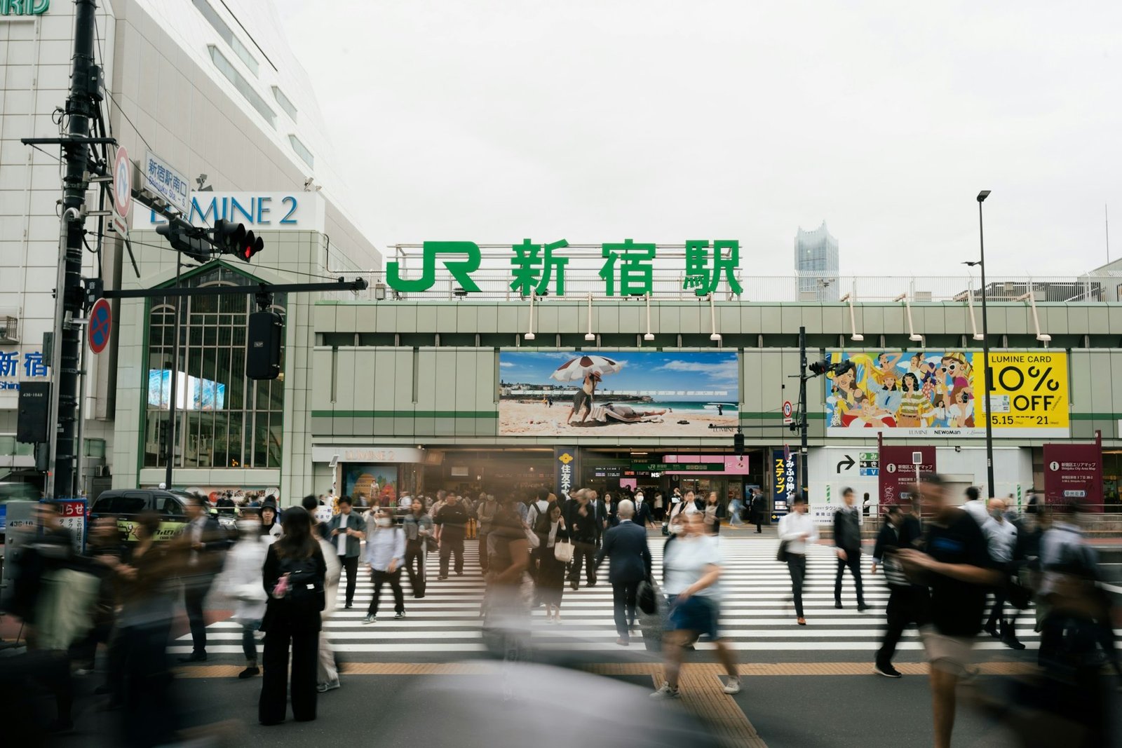 «No hagas fotos sin permiso»: el cartel de la estación de Shinjuku que ha causado revuelo 2026 Gente cruzando una calle frente a una estación de tren en Tokio