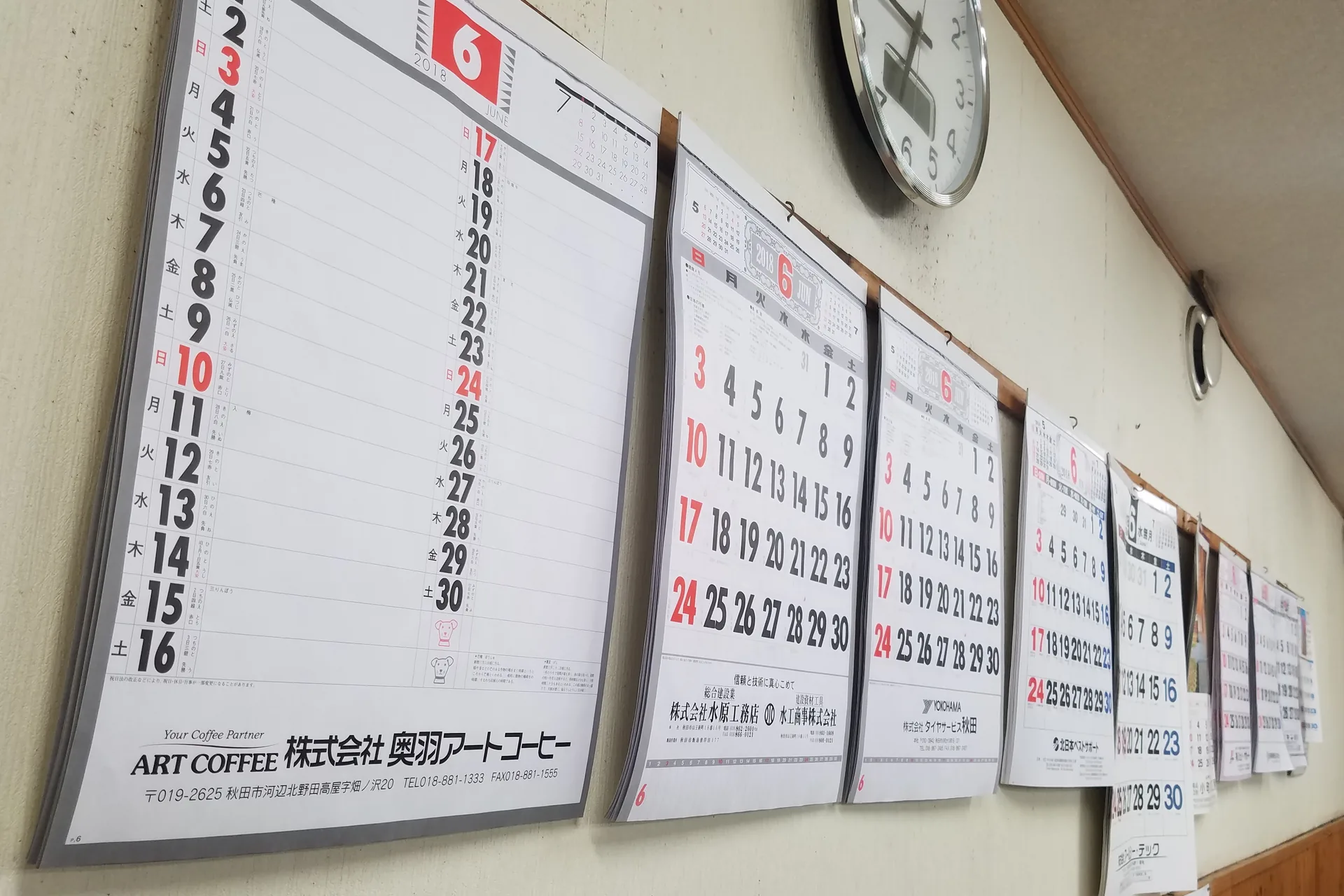 Días de la semana y meses en japonés: kanji y lectura 2026 Calendarios japoneses colgados en la pared de una oficina con un reloj al fondo