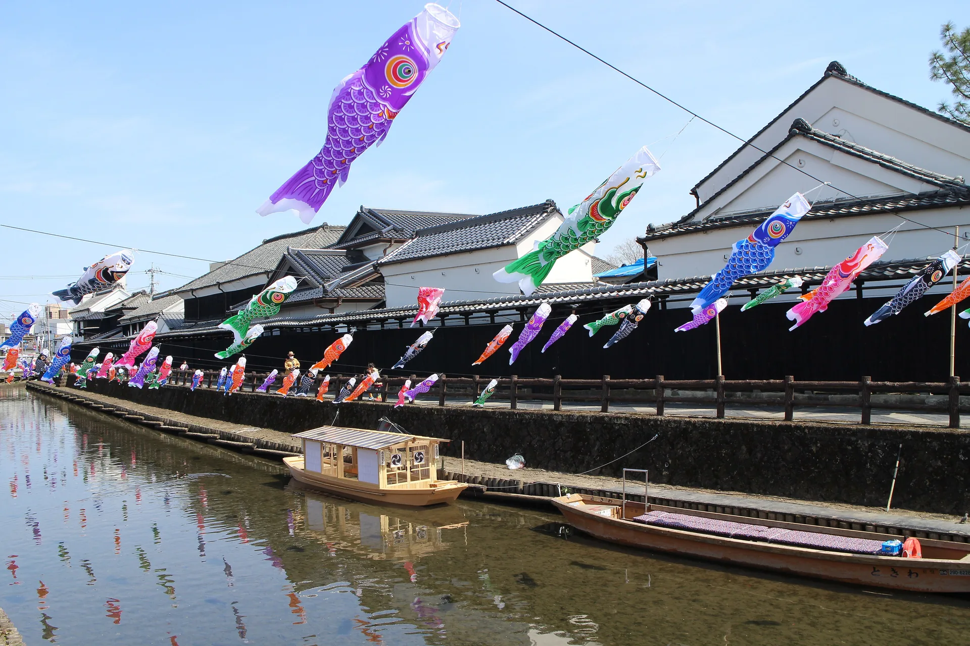 Koinobori, banderas con forma de carpa, colgadas sobre un canal entre almacenes antiguos de Tochigi