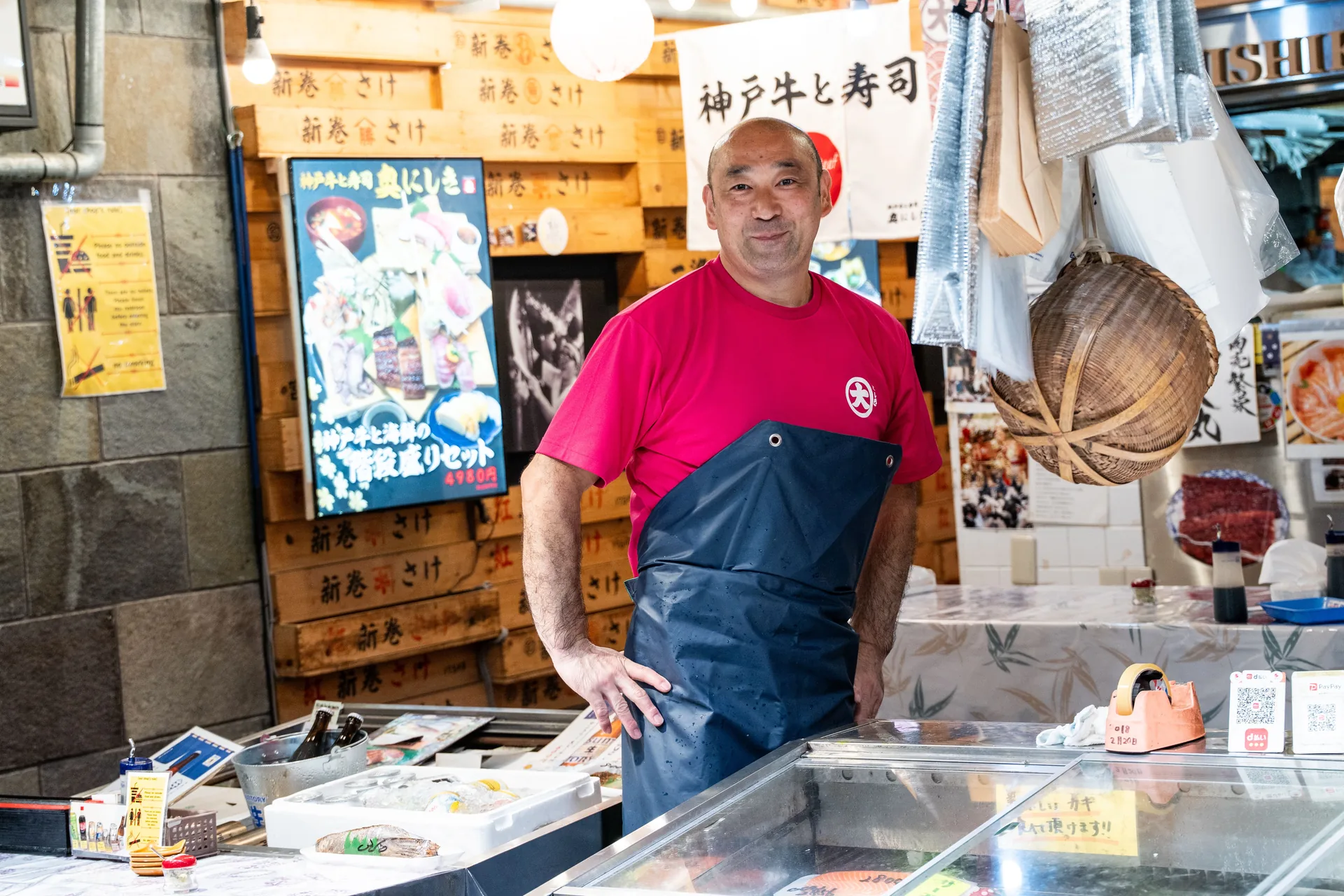 Vendedor sonriente en un puesto de un mercado tradicional japonés