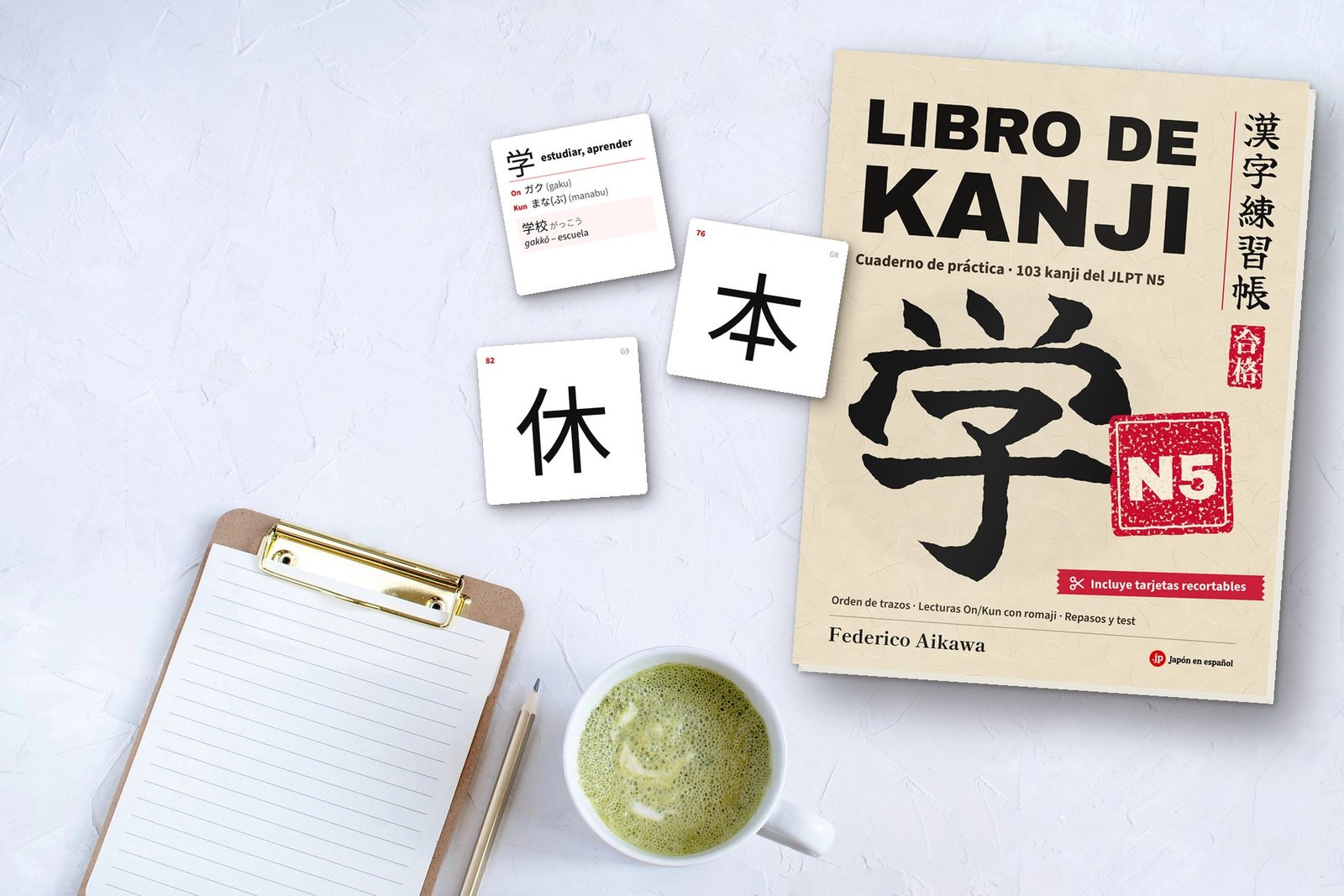 Libro de kanji N5 de Federico Aikawa sobre una mesa con tarjetas recortables de kanji y un matcha