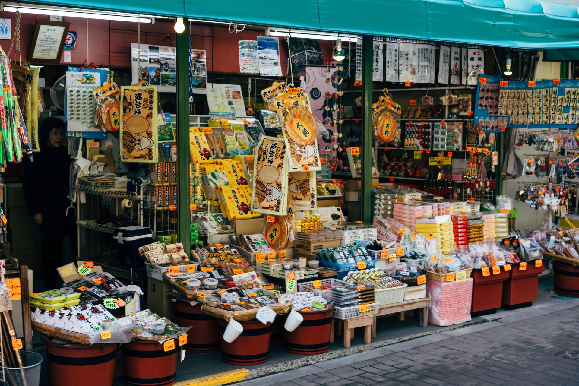 Qué comprar en Japón: souvenirs típicos, precios y dónde comprarlos 2026 Tienda de souvenirs japoneses con productos expuestos en la calle en Hachioji, Tokio